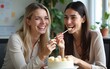 © fu - Two smiling women in the office eating cake. High quality