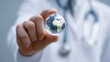 © AndiAzis - Close-up of a healthcare professional holding a digital globe representing global health