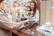 © Renata Hamuda - Senior woman customer giving prescription medications to female Pharmacist in a pharmacy