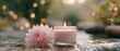 © praewpailyn - Soft pink flower and lit candle create peaceful spa atmosphere for wellness and care meditation enhancing relaxation and calm in serene natural setting
