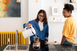 © Studio Marmellata - Two young women prepare pour-over coffee in a bright, modern kitchen. One carefully pours hot water from a kettle into the filter while her friend observes. A shared morning ritual.