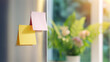 © BetterPhoto - Sticky notes in soft sunlight on glass window with blurred flowers behind, concept of organization, creativity and planning with calm mood.