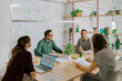 © Westend61 - Colleagues having a meeting in a modern office with plants and laptops