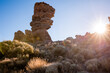 © Travel 'n' Lifestyle - View of sunlight streams across the arid landscape, illuminating the rugged rock formations with a golden glow, El Teide National Park, Canary Islands, Spain.