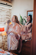 © qunica.com - Two friends share a lighthearted moment at home, with one singing into a brush microphone and the other styling hair. The cozy setup and cheerful vibes capture a bond and carefree enjoyment.