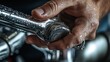 © nina blez - plumber fixing leaking faucet. Close-Up of Hand Holding Wrench Tightening Leaking Metal Faucet with Water Droplets for Plumbing, Maintenance and Emergency Home Repair Concept