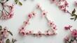 © Yuliia - Pink cherry blossoms arranged in triangle shape on white background, surrounded by scattered flowers and green leaves.