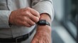 © PirisaTK - A man adjusts a smartwatch on his wrist, showcasing technology and personal health monitoring.