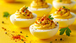© hardvicore - Delicious deviled eggs garnished with paprika and fresh herbs on yellow background. Tasty food