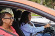 © Sabrina - Young african woman driving a car with female instructor - Driving licence, family lifestyle and transportation concept - Focus on girl face