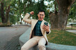 © PaeGAG - Excited man celebrating online success checking smartphone outdoors