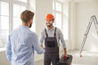 © Studio Romantic - Meeting shaking hands in empty room near ladder, two men interacting, worker wearing hard hat and carrying toolbox smiling, professional repair agreement made or service trust and positive emotion