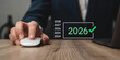 © Mehdi - Hand using a computer mouse to select the year 2026 planning and forecasting for business growth with a focus on future success