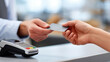 © Tetyana - Customers hands exchanging a credit card for a payment transaction at a retail point of sale terminal, completing a secure financial purchase in a shop or store with copy space