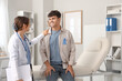 © Pixel-Shot - Young man with blue ribbon and female doctor in clinic. Prostate cancer awareness concept