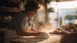 © CYBERPINK - Woman in a kitchen, kneading dough on a wooden table. she is wearing a striped apron and has curly hair.