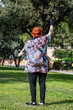 © Menorcaevo - Mujer de 60 años alegre y sonriente en el parque  saludando con los brazos