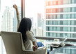 © Chinnapong - Work-life balance and life quality lifestyle of lazy businesswoman, businesswoman relaxing sitting in rest, take it easy in luxury hotel guest room or city home condominium living room with city view