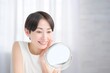 © Yamatatsu - 鏡を見て肌を確認する日本人女性