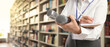 © New Africa - Journalist with microphones writing in notebook near shelves in library, closeup. Banner design