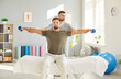 © Studio Romantic - Man patient sitting on the couch in rehabilitation clinic doing sport exercise using dumbbells with nurse. Physiotherapist helping patient in lifting dumbbell. Physical rehabilitation concept.