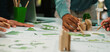 © InfiniteFlow - A dynamic workspace showcases hands of diverse individuals engaged in analyzing and sketching sustainable design concepts, emphasizing teamwork and eco-friendly strategies. SACTR
