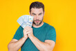 © Volodymyr - Man hold money on yellow studio isolated background. Portrait of rich man with money dollar bills. Successful guy with dollar banknotes. Rich millionaire holding money.