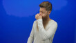 © Krakenimages.com - Young man with long ginger beard wearing casual white shirt pinching nose with closed eyes in bright blue studio; disgust.