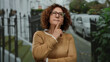 © Krakenimages.com - Woman pondering on city street, middle-aged fashion in urban background suggesting thoughtful reflection outdoors.