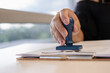 © Lahmz - Close-up of a businessperson stamping a contract document, symbolizing approval, legal agreement, successful deal, authorization, and official corporate paperwork process.