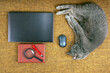 © photosaint - Cozy workspace with gray cat lounging next to laptop and office supplies on a textured surface