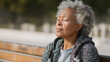 © Bonsales - Elderly woman enjoying a peaceful moment of relaxation and happiness with her eyes closed, basking in the warm sunshine outdoors