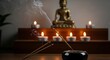 © Cowgirl - Smoking incense stick in the foreground. On background Small statue of Buddha with incense sticks and burning candles