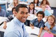 © Aliaksandr Barouski - Smiling teacher engaging with a diverse group of students in a classroom