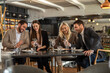 © Creative Light - Friends enjoying a meal together at a stylish restaurant, using their phones