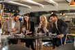 © Creative Light - Friends enjoying a meal together at a restaurant, looking at a phone
