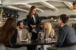 © Creative Light - Elegant restaurant scene with a server pouring champagne for a group of friends