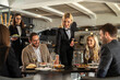 © Creative Light - Restaurant staff serving food to happy customers at a stylish dining table