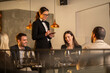 © Creative Light - Elegant restaurant scene with a waitress taking orders from happy customers