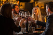 © Creative Light - Friends toasting with wine glasses at a restaurant, celebrating a special occasion