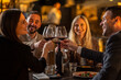 © Creative Light - Friends toasting with wine glasses at a restaurant, celebrating a special occasion