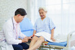 © DG PhotoStock - Doctor checking elderly patient’s knee for osteoarthritis.