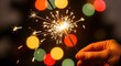 © icik icik bum - Celebratory Sparkler held against a bokeh background with festive New Year's spirit