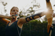 © Jacob Lund - Focused female archer practicing outdoors