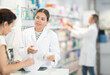 © JackF - Young female pharmacist giving prescription medicine to adult female buyer at pharmacy