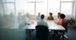© al-sultan - Blurred office meeting with diverse people around a conference table, showing collaboration, inclusion, and teamwork in a bright modern environment that reflects unity and professionalism.