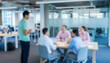 © al-sultan - Blurred office meeting with diverse people collaborating around a table, showcasing teamwork, creativity, and discussion in a bright modern professional workspace.