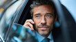 © NBLX - Confident businessman is talking on his cell phone while sitting in a car. He is wearing a suit and tie