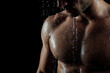 © Volodymyr Hankevych - Muscular man under shower with water droplets on his skin against black background