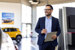 © Graphicroyalty - Successful deal in a car showroom. Handsome male car salesman working in the showroom. Salesperson at car dealership selling vehicles.